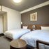Hotel Route-Inn Iwakiizumi Ekimae guest room with two twin beds and entry door in Iwaki