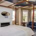 Almondy Inn, Newport: elegant four-poster bedroom with fireplace, bay windows, blue loveseat and sitting area