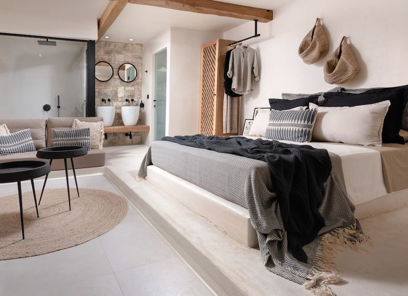 Emery Hotel in Naxos: bright bedroom with platform bed, sitting area, and open bathroom with double sinks