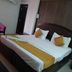 Hotel Meena Paradise, Visakhapatnam: double bed with white bedding and mustard runner in a simple guest room