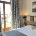 Hôtel Des Princes in Évian-les-Bains guest room with bed, balcony doors, and lake view
