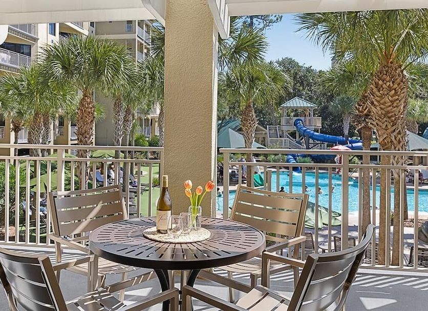 Marriott's Barony Beach Club, Hilton Head Island: patio table overlooking palm-framed pool and waterslide