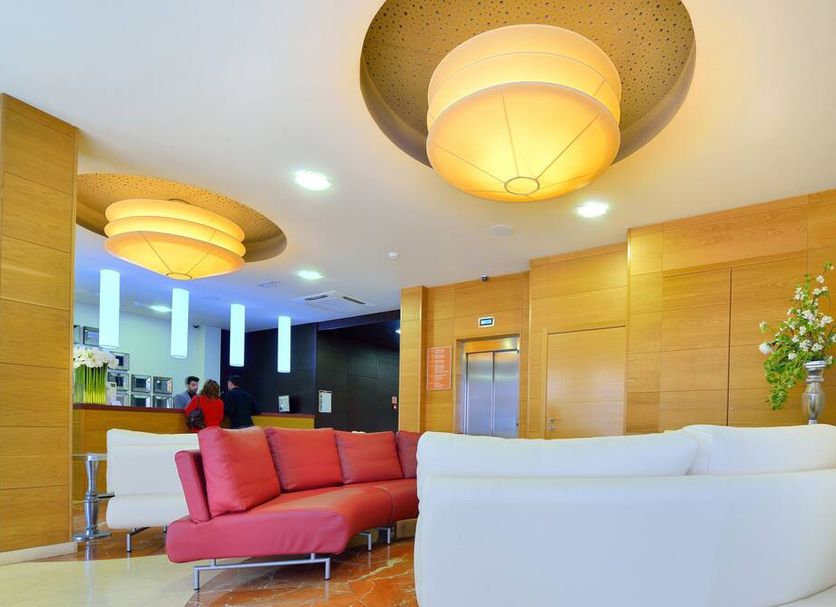 Hotel Norat Marina & Spa 4 Superior lobby in O Grove with red and white sofas and warm pendant lights