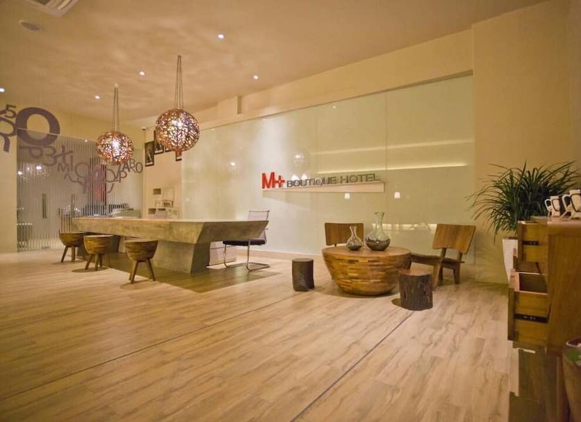 M Plus Boutique Hotel in Ulu Tiram lobby with wooden seating, pendant lights and reception desk