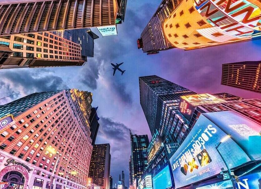 Executive Hotel Le Soleil New York surrounded by skyscrapers and an airplane overhead in New York