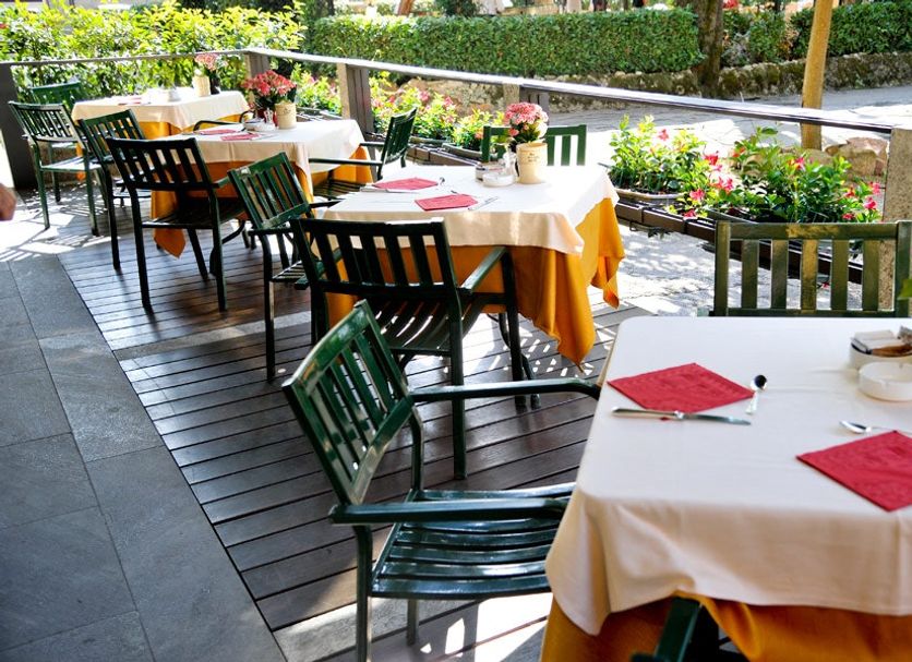 Hotel Ristorante Vecchia Riva in Varese: outdoor terrace dining tables with flowers and chairs