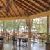 La Ensenada Beach Resort in Tela: open-air restaurant with wooden tables and a beach view