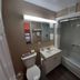 Howard Johnson by Wyndham Woodstock NB bathroom with tub-shower, vanity sink, toilet and mirror