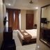 Hotel Shreehari Grand in Puri guest room with bed, wall-mounted TV, wardrobe, and mirror