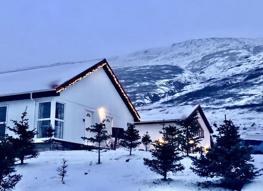 Country Hotel Heydalur in Sudavik with snow-covered cabins at the foot of a mountain