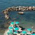 Hotel Esperia in Piombino: seaside terrace with turquoise umbrellas and rocky cove with clear water