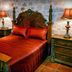 Olympia Villas Stoupa bedroom with ornate bed, red bedding, and bedside lamps
