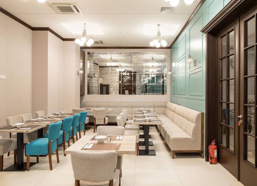 Concorde Old Bucharest Hotel dining room in Bucharest with turquoise chairs and beige banquettes