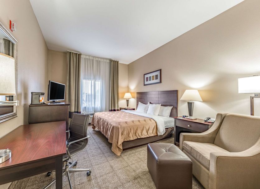 Quality Inn West Plano - Dallas guest room with king bed, desk, TV, and seating area in Plano