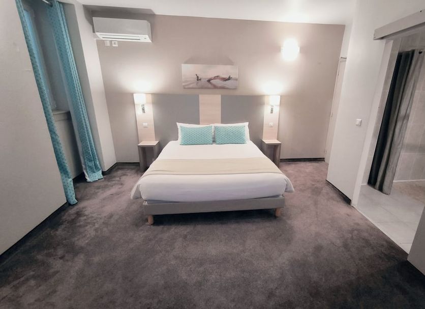 Hotel Du Midi Nice guest room with double bed, teal accents, wall art and gray carpet
