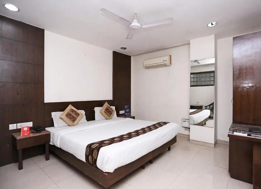 Hotel O Grand Peepal room with king bed, air conditioning, mirror and wood furnishings in New Delhi
