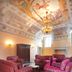 Villa Fenaroli Palace Hotel in Brescia lounge with ornate painted ceiling and red armchairs