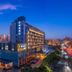 Puruihotel Yongkang in Jinhua at dusk, illuminated modern hotel exterior with city skyline and traffic