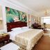 Paragon Hotel Xiangtan guest room with king bed, floral wall art, seating area and large window