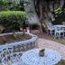 La Teresita Hotel Boutique in Salta with a leafy courtyard, white metal tables and chairs, and tiled planters