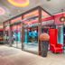 Leonardo Hotel Munich City South lobby with red velvet chairs, glass walls and colorful lighting