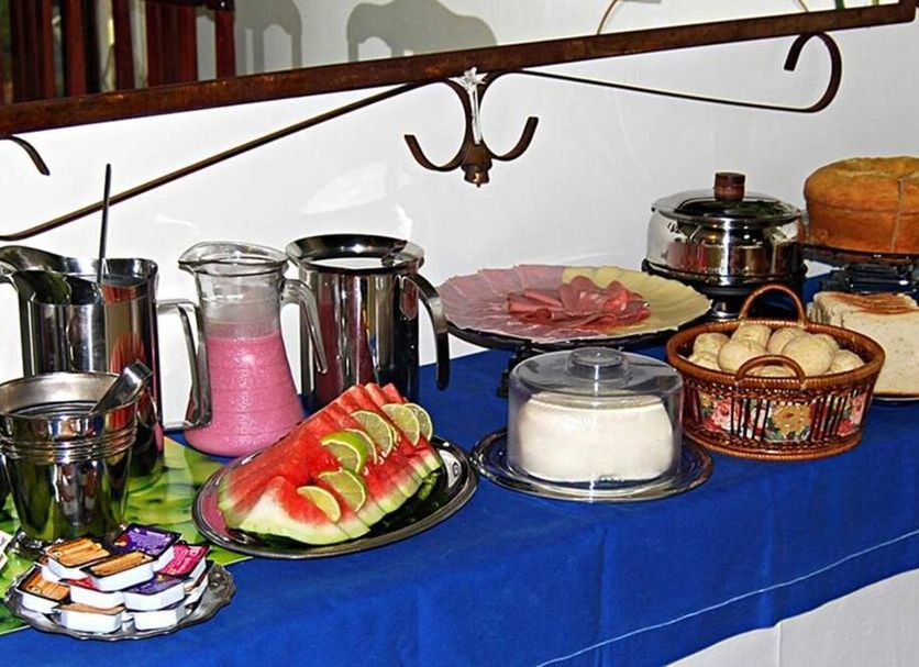 Hotel Pousada do Comendador breakfast buffet with fruit, breads, yogurt and drinks in Guarujá