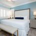 Crane's Beach House Boutique Hotel & Luxury Villas guest room with king bed, bench, and bedside lamps in Delray Beach