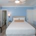 Crane's Beach House Boutique Hotel & Luxury Villas room with bed, blue walls, shutters, and ceiling fan