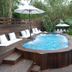 Villas Sur Mer in Negril features a wood-decked plunge pool beside a larger pool and tropical greenery.