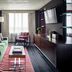 Graduate by Hilton Columbus guest room with green sofa, wall-mounted TV, and window seating