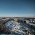 The Explorer Hotel in Yellowknife with panoramic snowy city views under a clear blue sky.