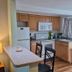 Studio 1 Motel in Daytona Beach kitchenette with white appliances, wood cabinets, breakfast bar and chairs