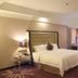 Clayton Hotel Guangzhou room with king bed, seating area, and floor-to-ceiling curtains