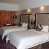 Clayton Hotel Guangzhou guest room with two white beds, mirrored headboards, and purple carpet