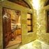 Anitya Cave House in Ürgüp: stone cave courtyard with arched walls and open doorway to kitchen