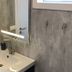 Afternoon Cottages in Hella bathroom sink with mirror, wall light, and concrete-style walls