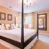 Brick Street Inn in Zionsville bedroom with four-poster bed, desk, lamp, and large wall mirror