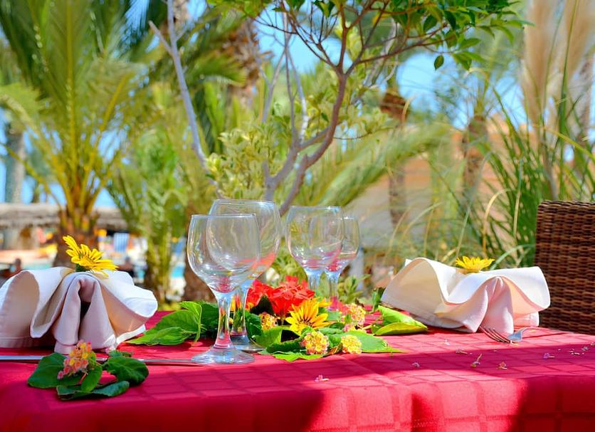 Vincci Safira Palms in Zarzis: table set outdoors with wine glasses, napkins, flowers and palm trees
