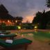 Belle Villa Resort, Pai poolside loungers at dusk beside a lit outdoor pool and thatched pavilion