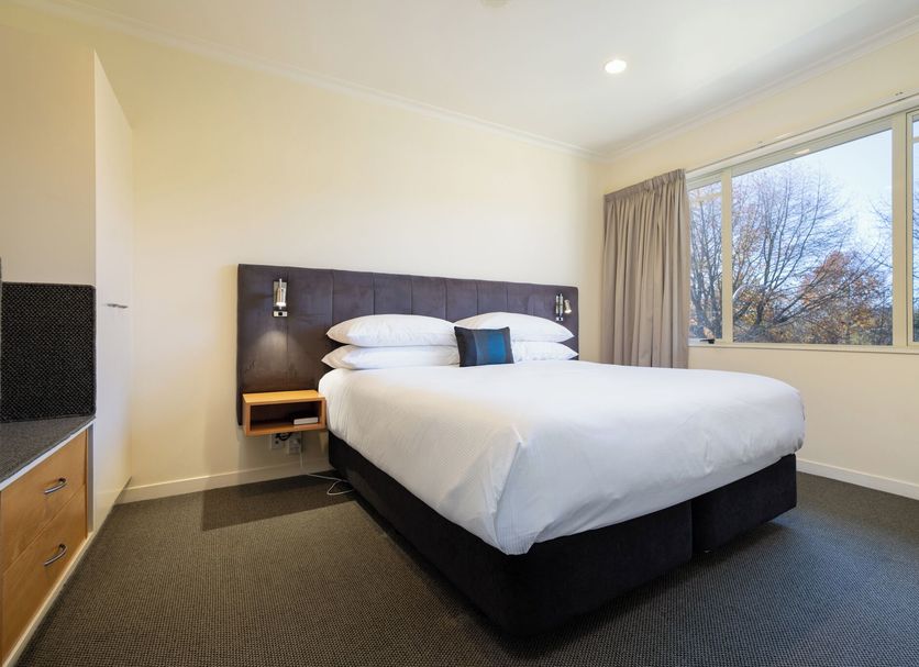 Regal Palms Resort in Rotorua guest room with king bed, large window, and neutral decor