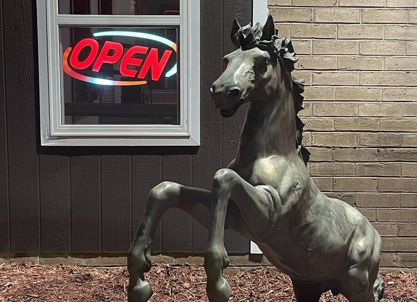 Stratford House Inn Branson exterior with rearing horse statue and open neon sign