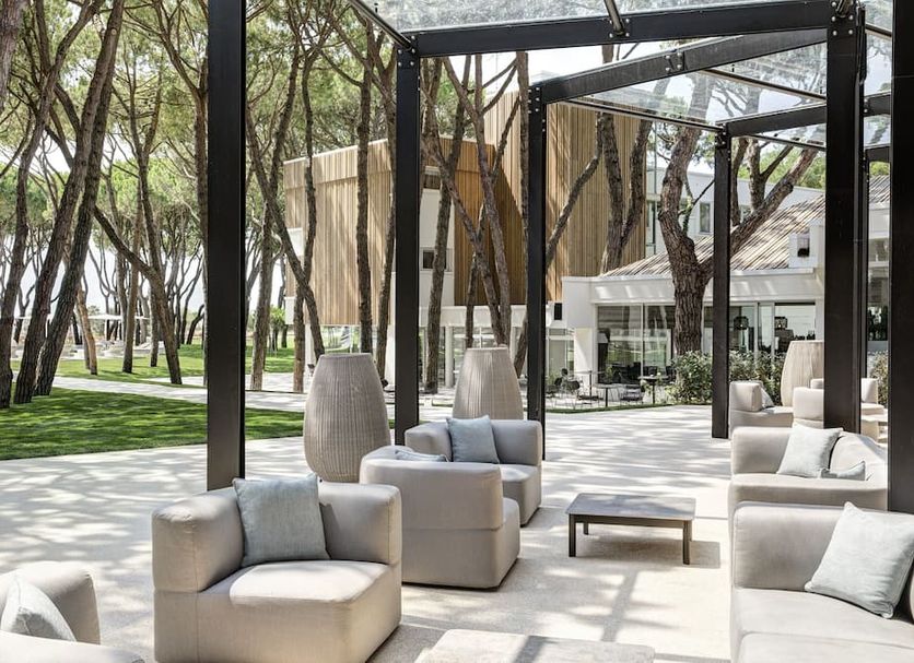 Outdoor lounge at Bellevue Hotel & Resort in Jesolo with cushioned seating under a glass pergola