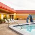 Pool area at Scottish Inn Downtown Jacksonville in Jacksonville with lounge chairs and palm trees