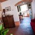 Agriturismo Villa La Morina in Cortona, rustic lounge with brick fireplace and tiled floor leading to window nook