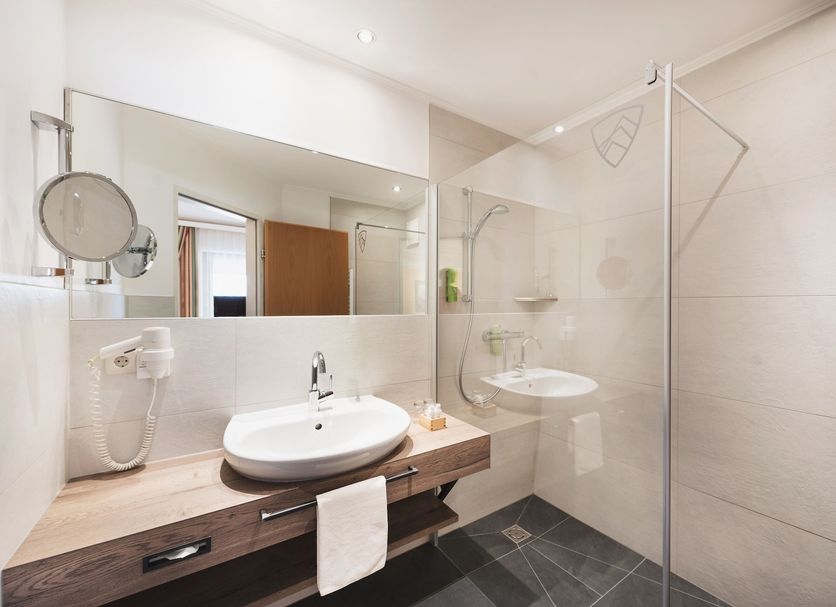 Spa & Naturhotel Outside bathroom with walk-in shower, vessel sink and large mirror in Matrei in Osttirol