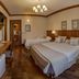 Hotel Solar d'Izabel room in Campos do Jordão with two beds and wood-paneled walls