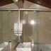 Pousada Innova in Natal bathroom with glass-enclosed tub and towel rack under sloped ceiling