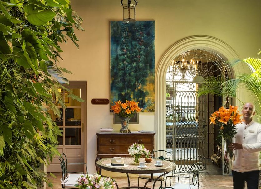 Las Casas de El Arenal, Seville: elegant courtyard with arched doorway, plants and small tables