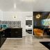 Hotel Zazz in Albuquerque: stylish suite with kitchenette, patterned backsplash, and orange chair
