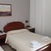 Emmanouela Studios & Villas in Thera room with two single beds, bedside tables, and folded towels